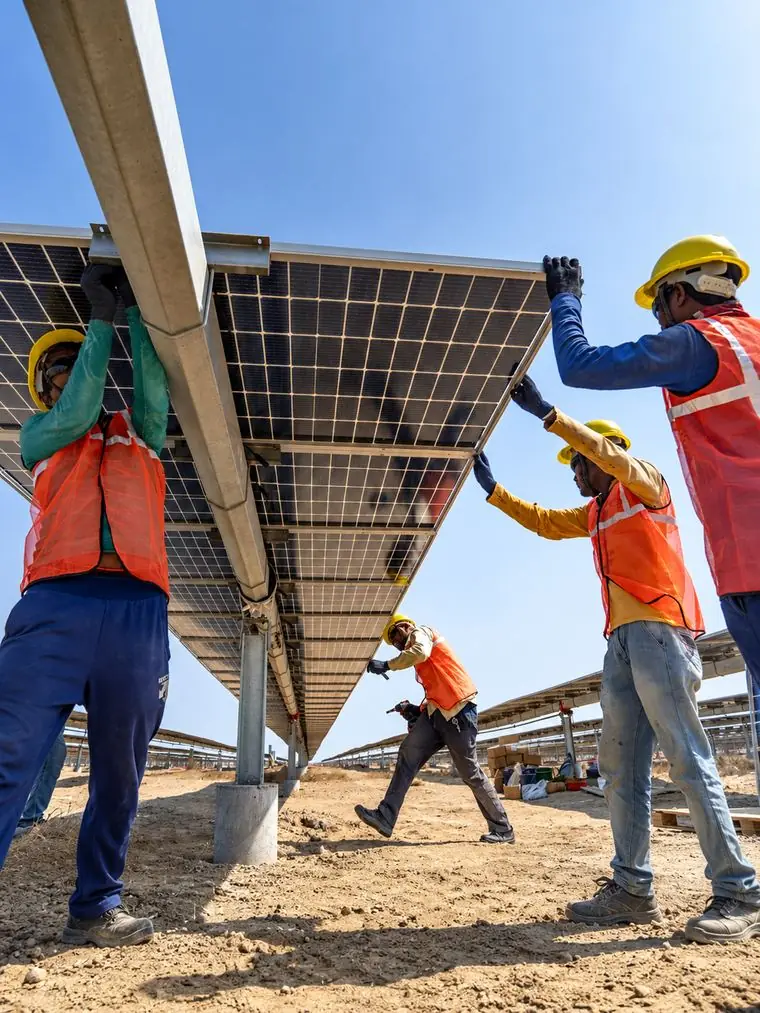 Installation crew lifting a solar panel into place